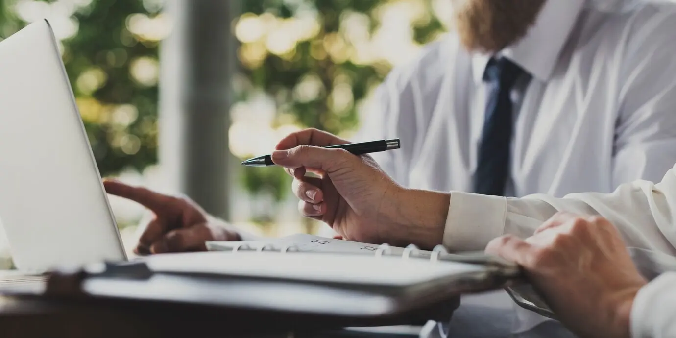 Деловые люди работают, используя ноутбук.